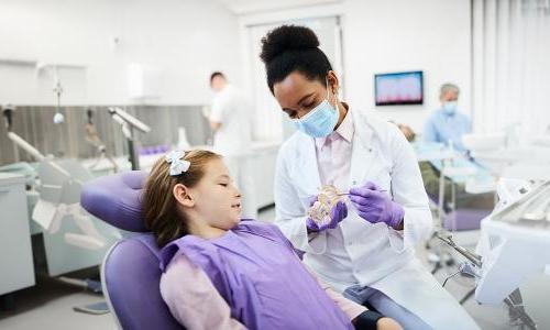 Dental hygienist who bridged from associate to bachelor's dental hygienist degree showing patient tooth structure 